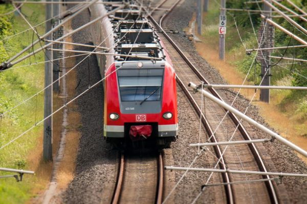 Train travelling underneath overhead wires